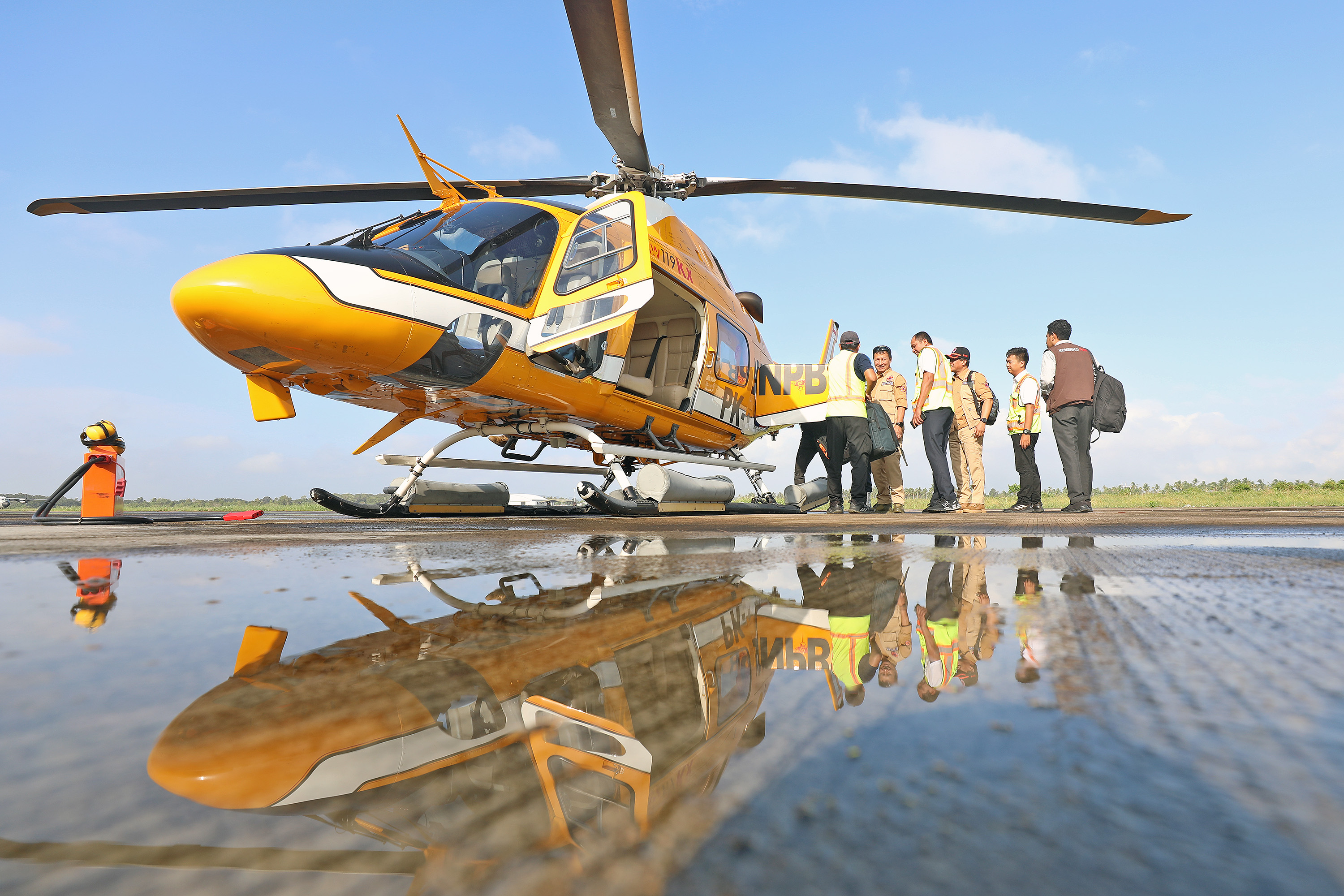 Tim BNPB bersiap onboard ke dalam helikopter di Lanut Sadjad Ranai, Natuna, Kepulauan Riau, Rabu (8/3).